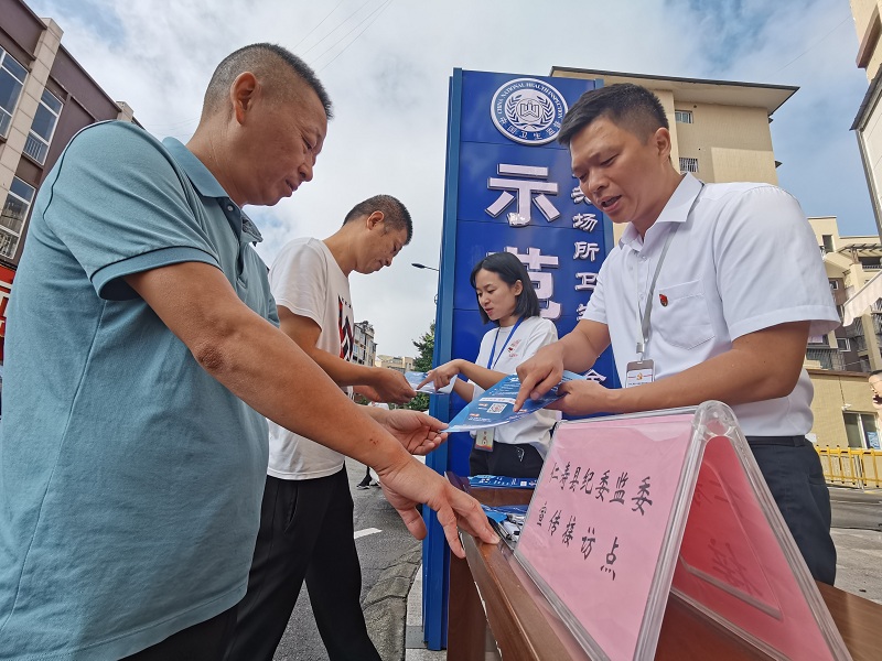 纪检监察干部向群众宣传小微权力“监督一点通”平台的操作知识。.jpg