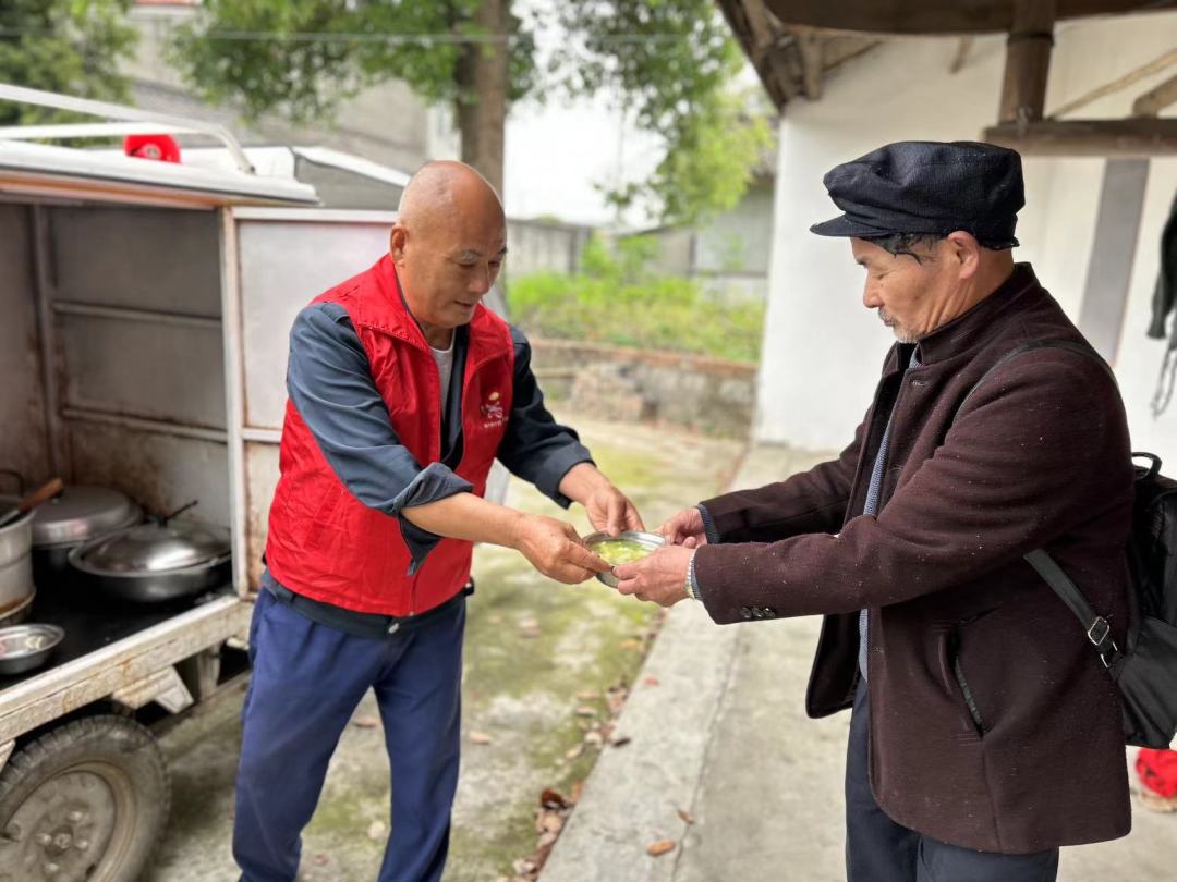 每天临近中午，送餐志愿者杨永东要将新鲜出炉的饭菜送到诸葛村18户老人的家中。.jpeg