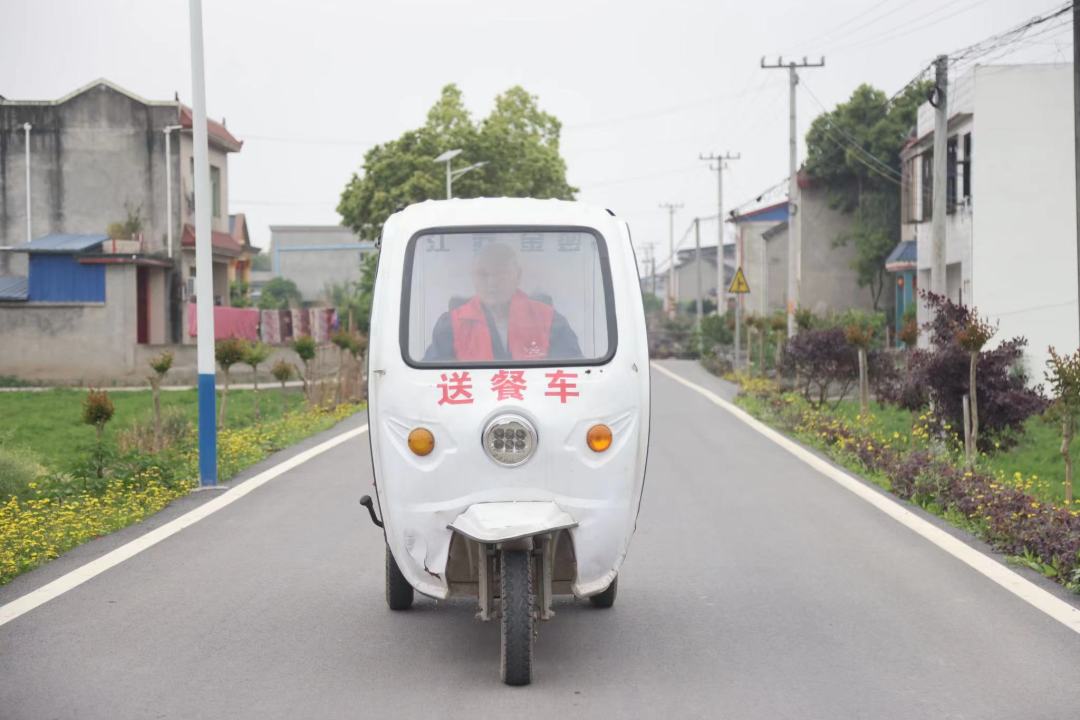 杨永东骑着“送餐车”，行驶在道路上。.jpeg