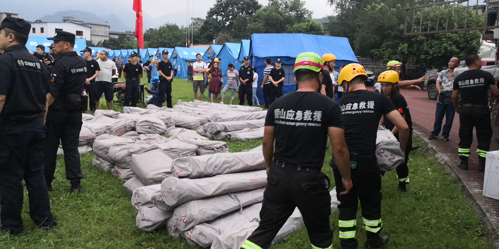 18日晚7时20分左右，救援队员和武警官兵冒雨为群众搬运救灾帐篷。2.jpg