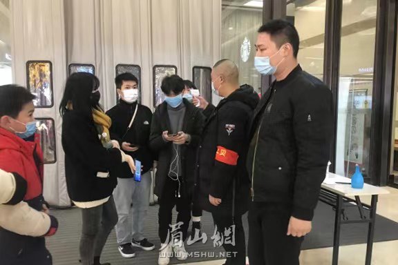 在城区一商场，市民排队测温和出示健康码。