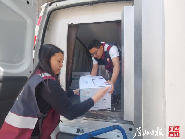  东坡区疾控中心工作人员把新冠疫苗搬运上冷链运输车。