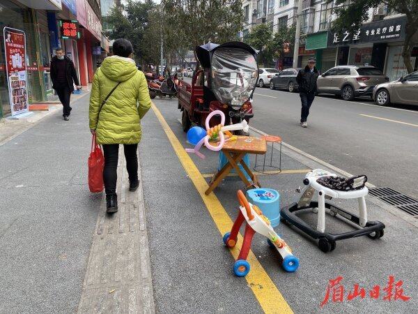 2月25日10时10分，彭山区灵石路，商家将小孩玩具摆放在了人行道上。
