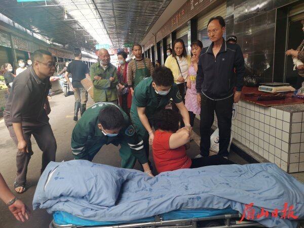  在张花园综合大市场事发现场，邹伟和同事将伤者抬上担架，紧急送往医院治疗。