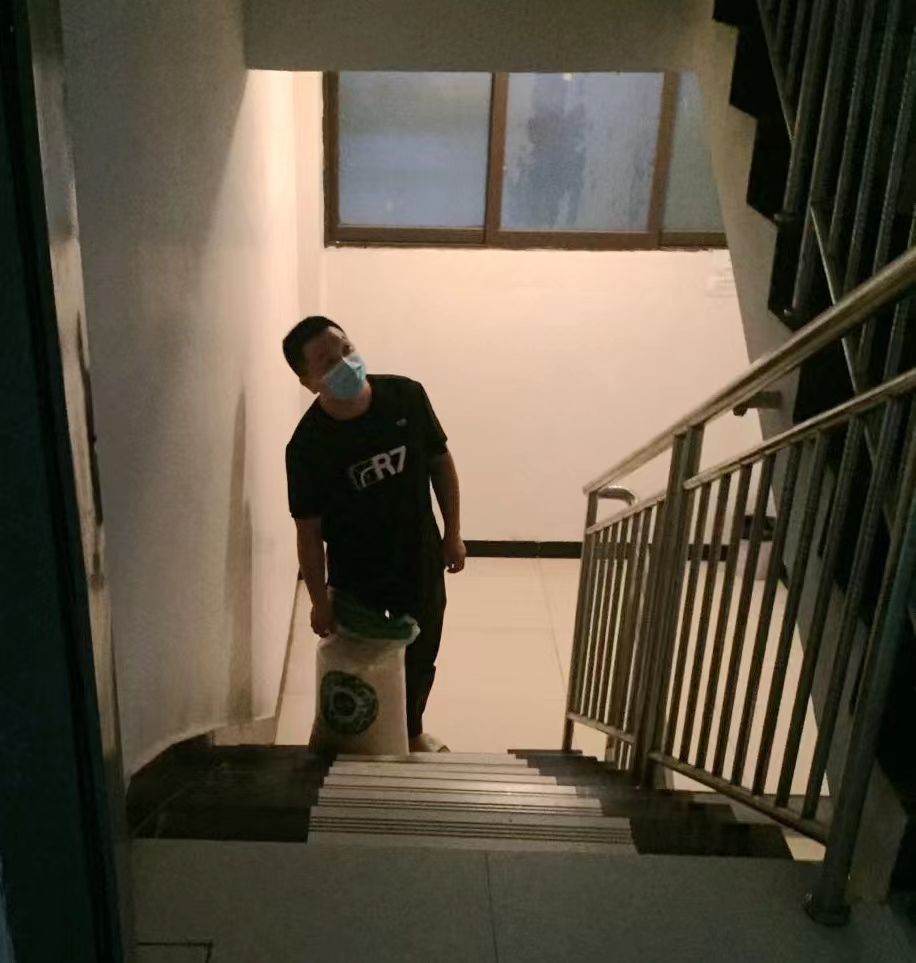 7月22日晚上，正给住户送物资的张宇航。（受访者供图）.jpg