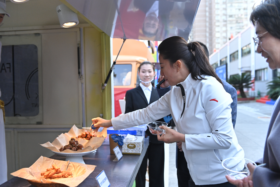  杨扬在王家渡食品工厂品尝美食。