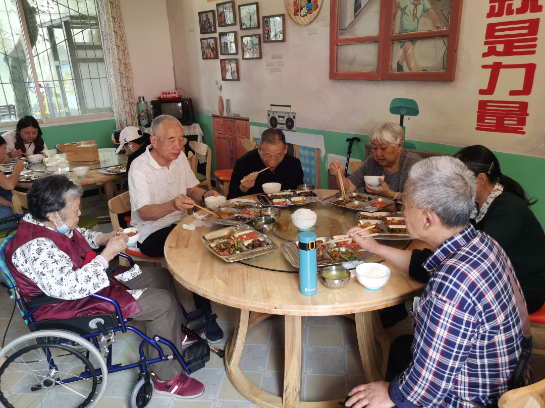  青神县爱邻厨房，老人们围坐就餐。