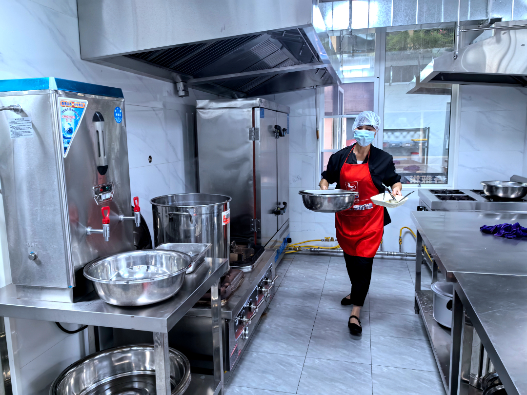  中央厨房内，工作人员正在整理做饭工具。
