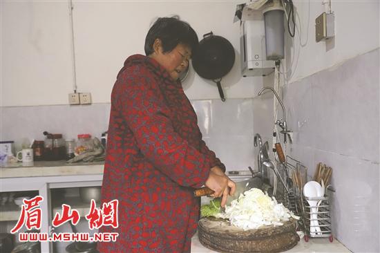 何学玉正在改造好的新厨房中做饭。.jpg