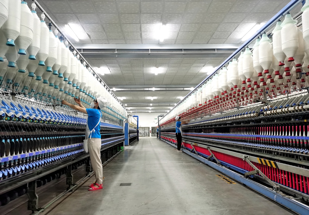 在四川省仁寿县金鹅纺织有限公司的生产车间内，工人正在忙碌工作。.jpg