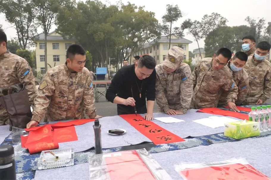 官兵们围在书法家身边欣赏书法作品。.jpg