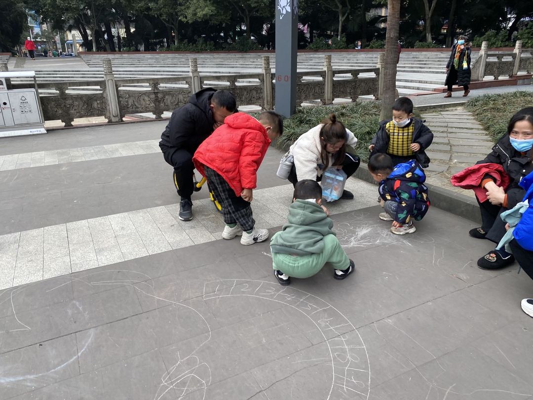 1月9日下午4时，一位市民带着四五名小朋友在公园的地上乱涂乱画。.jpg