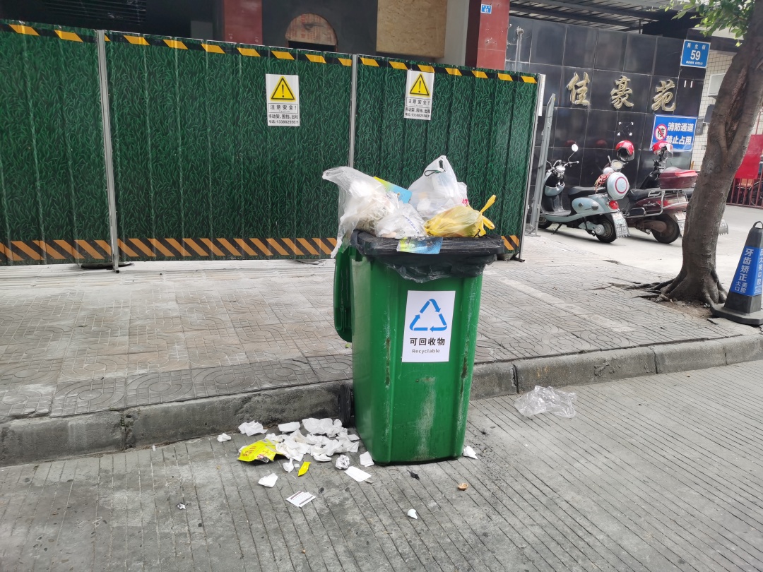 6月20日下午1点左右，东坡区民生街，一垃圾桶满溢，散发出阵阵恶臭，周边散落垃圾。.jpg